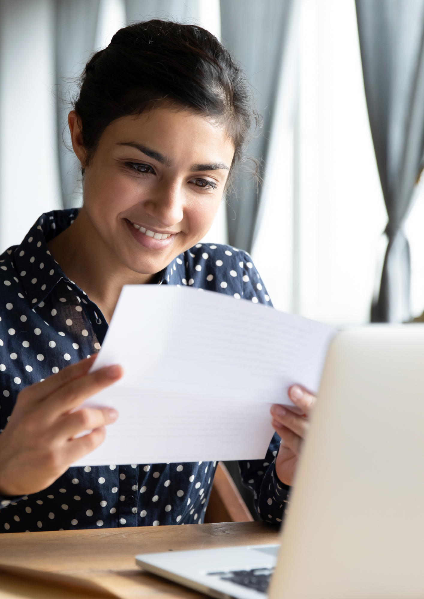Education Advice from Liz Taylor | Skills4Parents | Education Advice Call | Woman reading a document and smiling while sat in front of a laptop